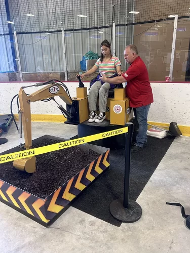 A student learns how to use a model excavator.