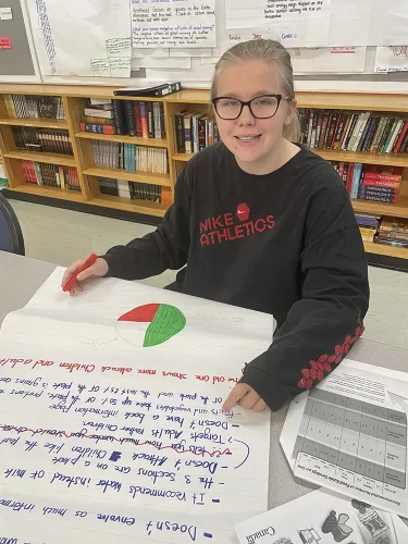 A student with a large literacy chart.