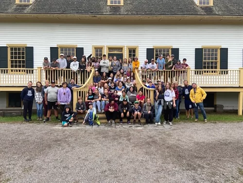 Large group poses on steps of a building.