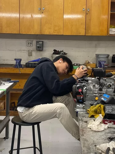 Student works on an engine in a shop class.