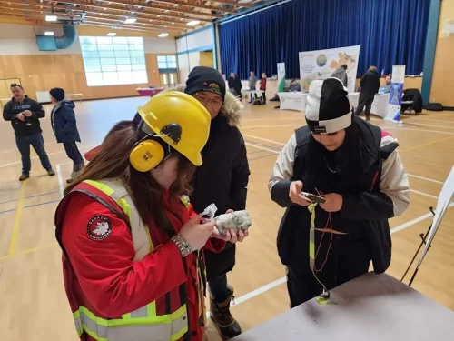 Students observe rock samples at a career fair.