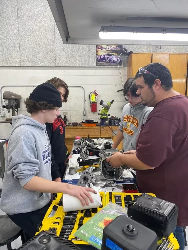 Teacher instructs students in a shop class.