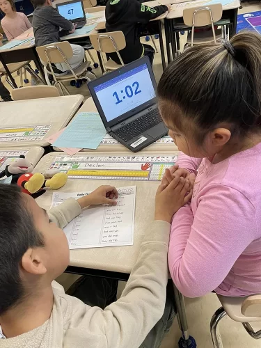 Two students working together on a literacy chart.