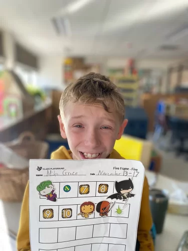 Special education student poses with his math chart.