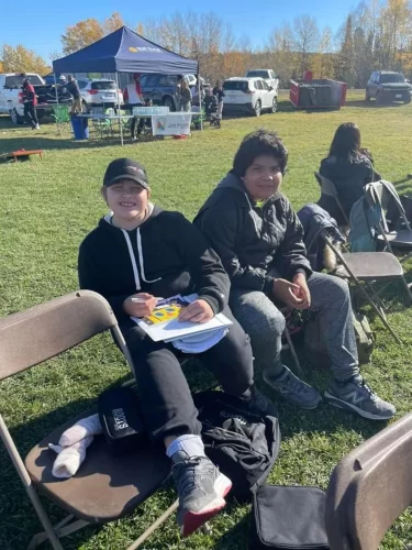 Two students pose for the camera while sitting at the Fall Harvest.